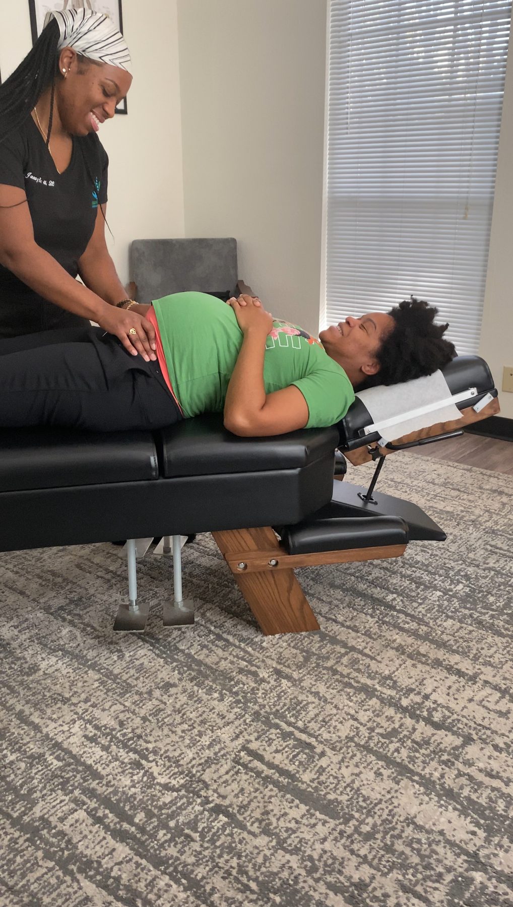 Dr. Janay Scott smiling as she adjusts a pregnant patient