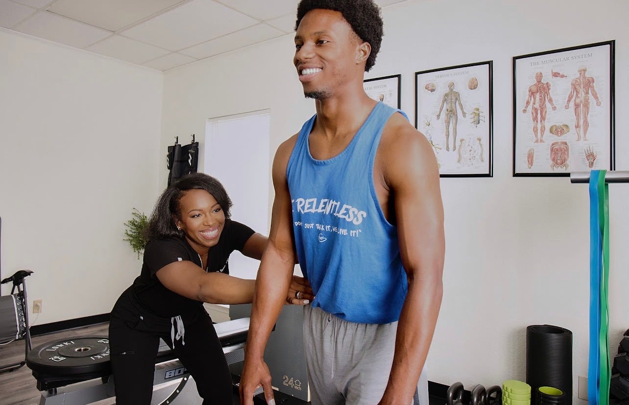 Dr. Janay Scott guiding a patient through a shoulder exercise in the rehab area
