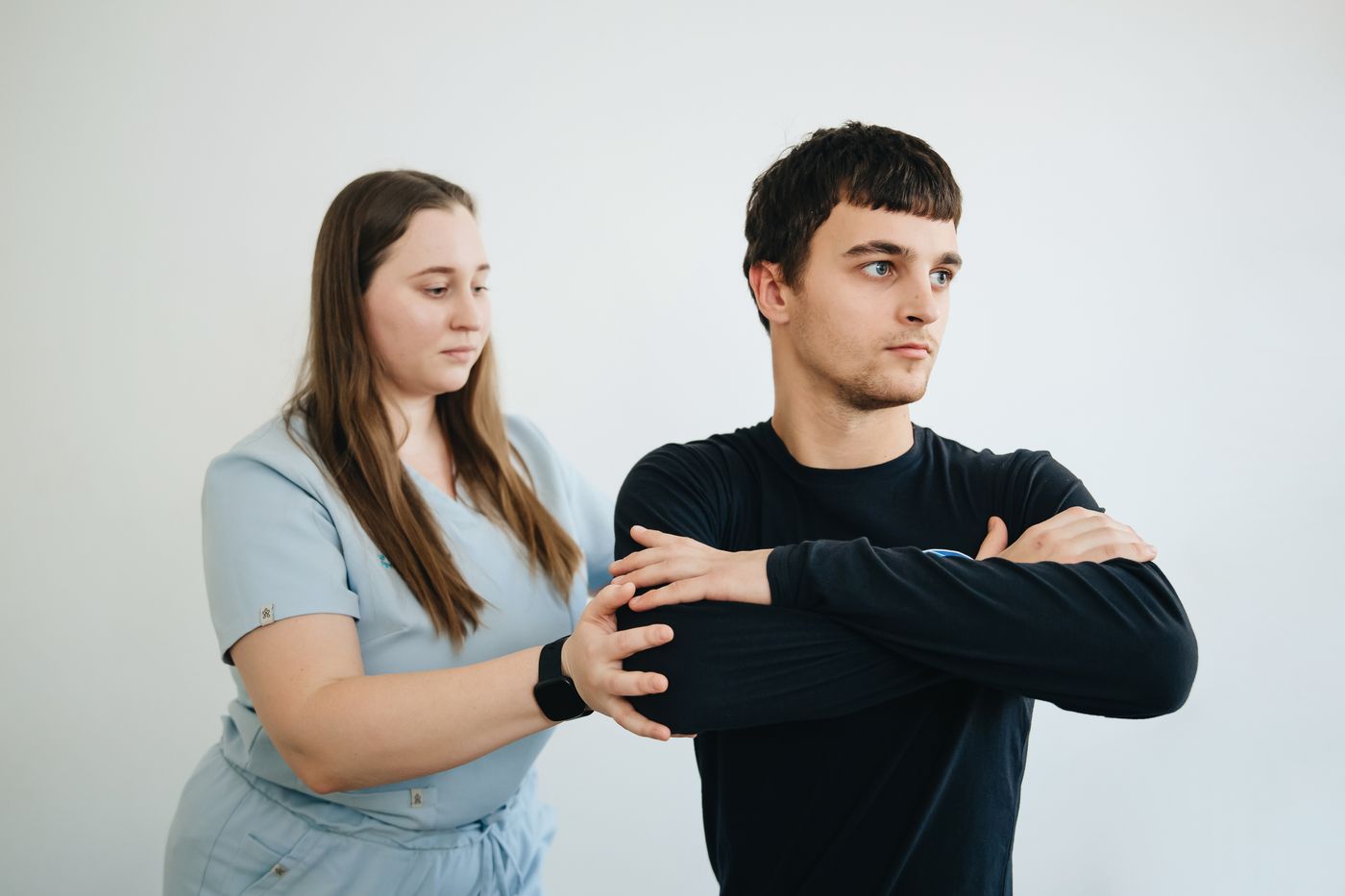 A practitioner guiding a patient through a shoulder exercise