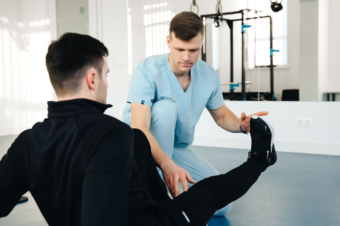 A practitioner assisting a patient with a supported stretch