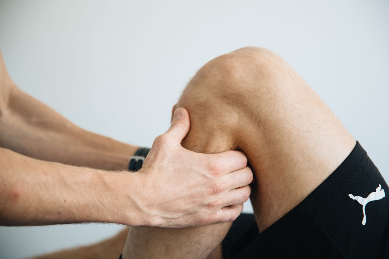 Hands-on soft-tissue work on an athlete's knee