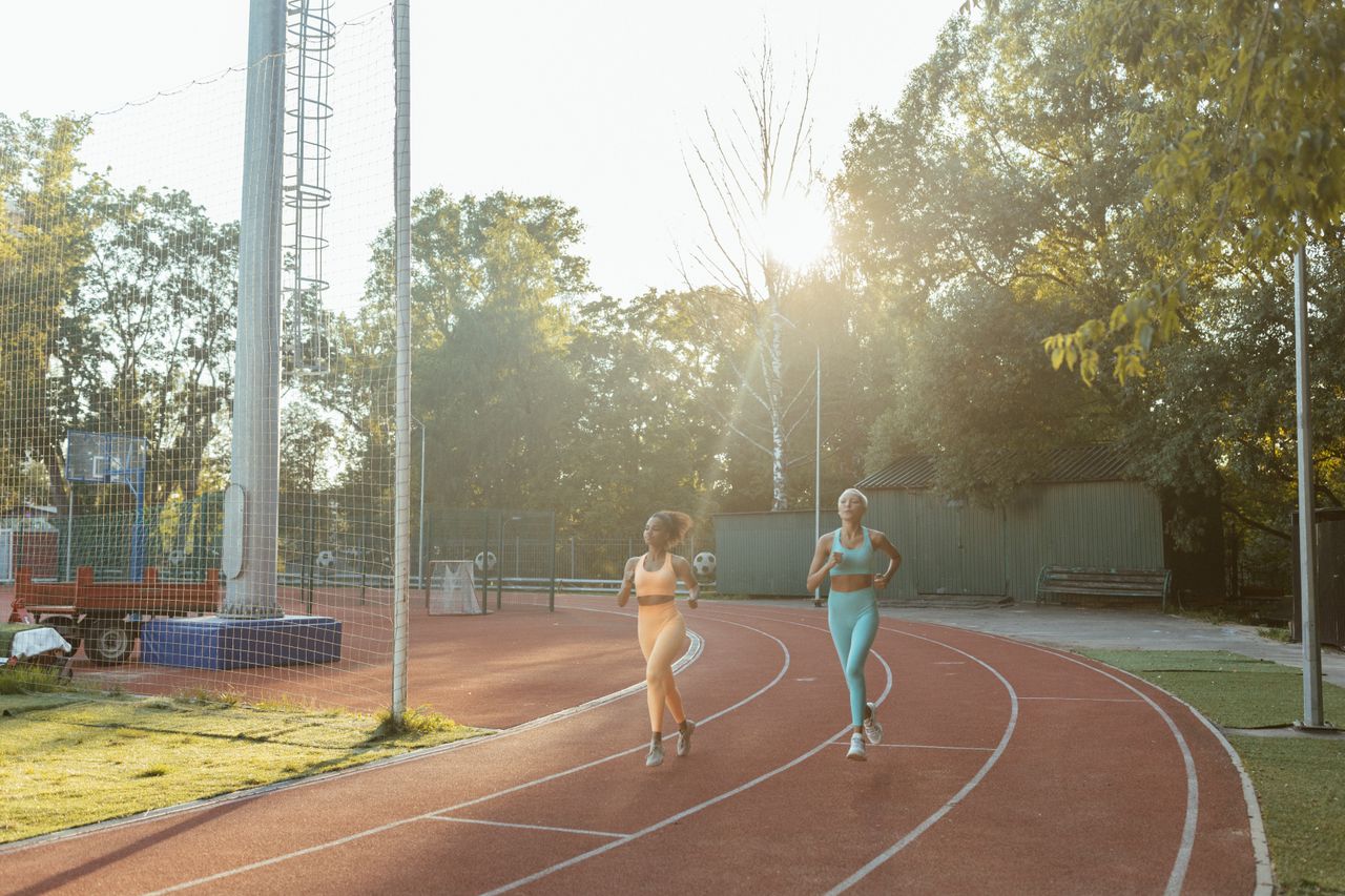 Two runners training on an outdoor track